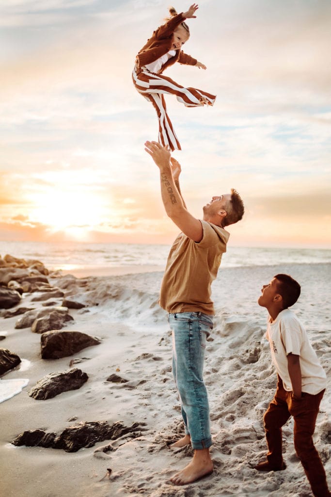 Family Photographer, Dad tosses daughter in the air as son watches
